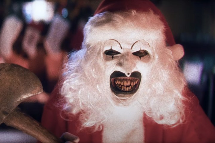 Art the Clown in a Santa costume brandishing an axe in Terrifier 3.