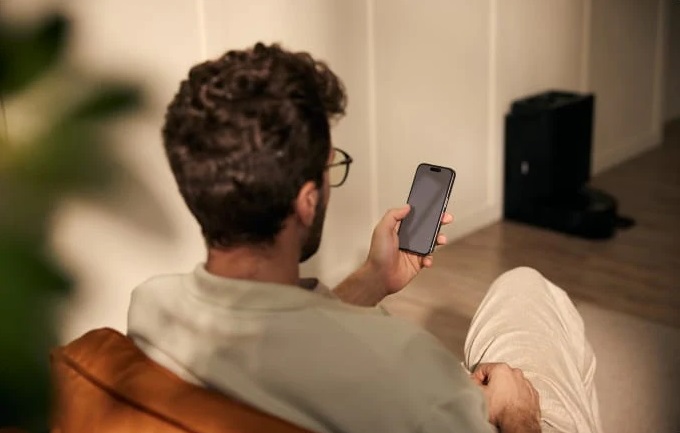 A person using a smartphone with the Qrevo Slim.