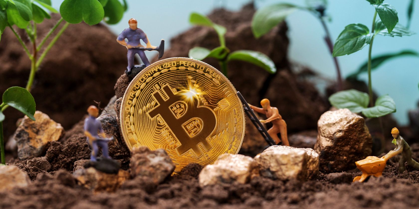 Miniature figures mining Bitcoin in a garden setting.