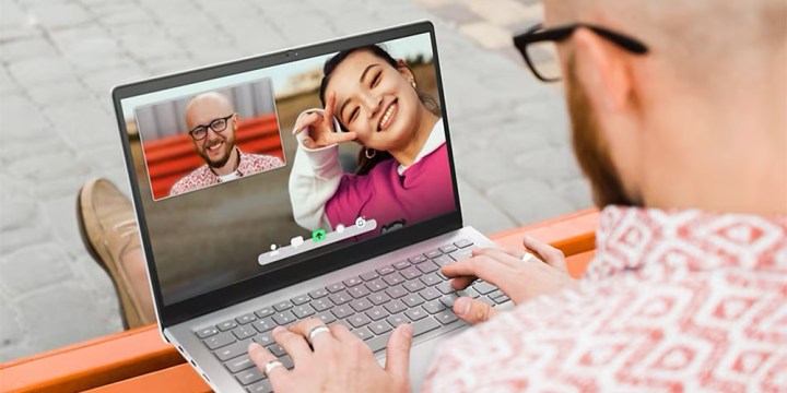 A person using a Dell Inspiron 14 laptop for a video call.