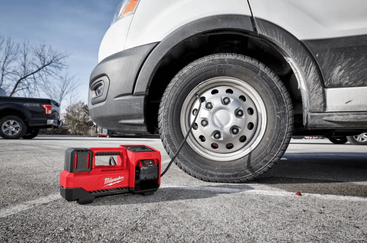 Milwaukee M18 Inflator attached to a vehicle tire.