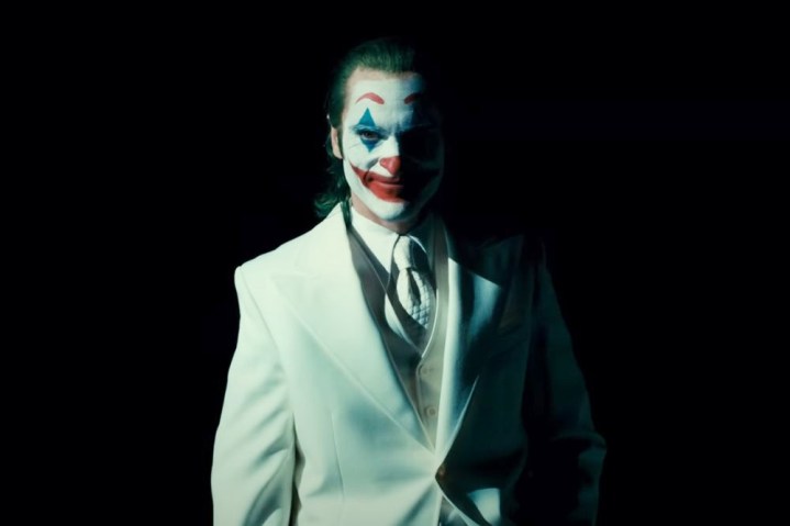 A man in a white suit smiles in Joker: Folie à Deux.