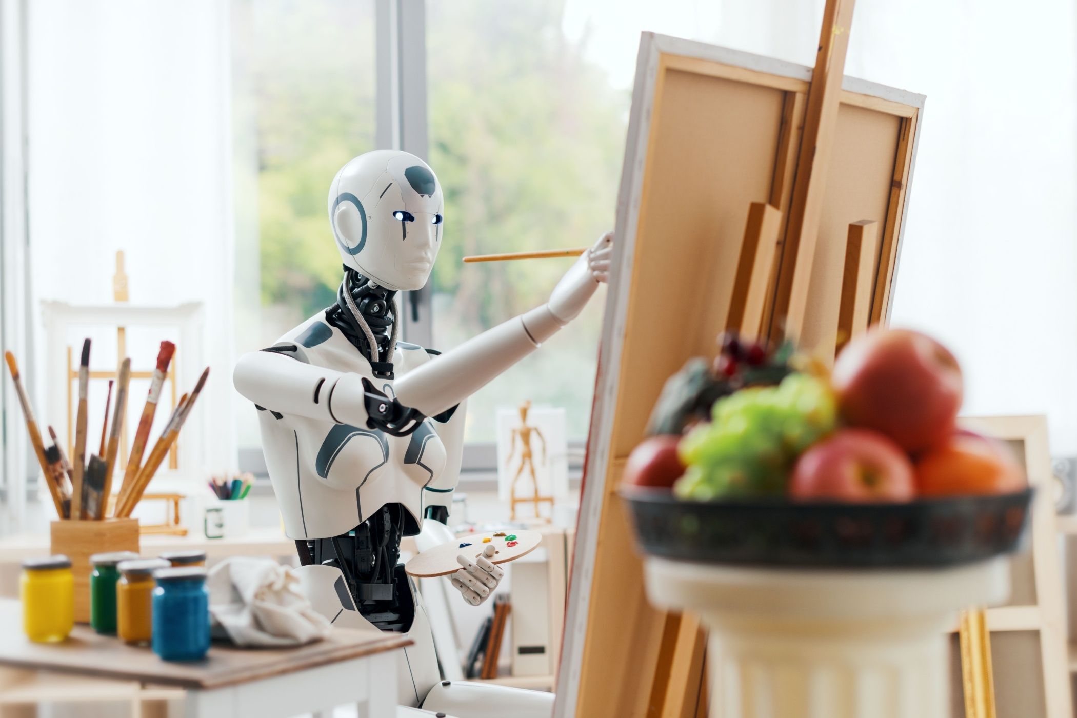 Humanoid AI robot painting a still life composition on canvas in the art studio