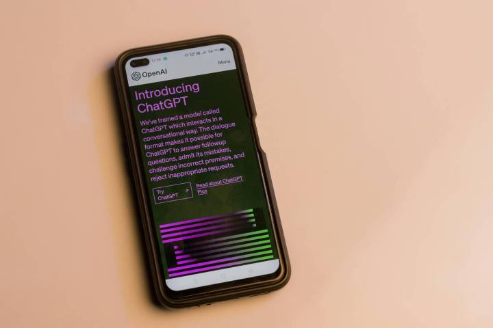 a phone showcasing the ChatGPT homepage on a beige background.