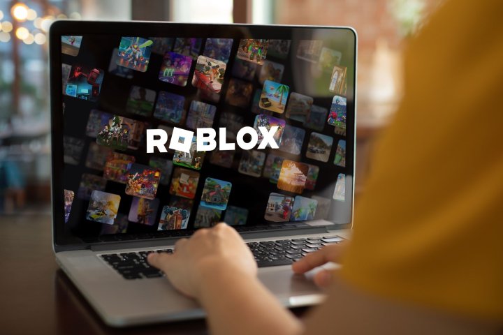 A laptop displaying a Roblox wallpaper.